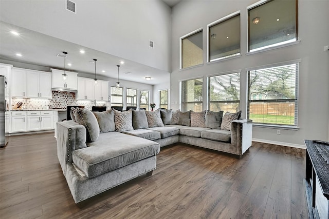 living room featuring dark hardwood / wood-style flooring and a high ceiling