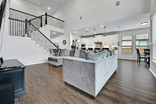 living room with dark wood-type flooring and high vaulted ceiling