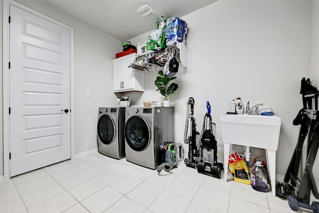 laundry area with cabinets, light tile patterned flooring, and separate washer and dryer