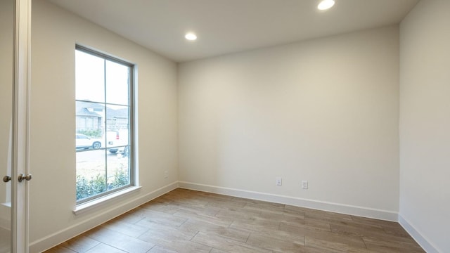 unfurnished room with a healthy amount of sunlight and light hardwood / wood-style floors