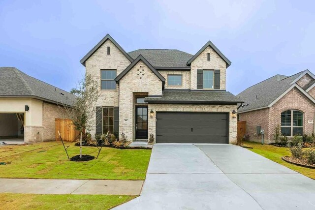 view of front of house with a garage and a front lawn