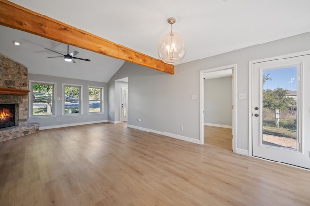 unfurnished living room with ceiling fan with notable chandelier, a fireplace, light wood-type flooring, and vaulted ceiling with beams