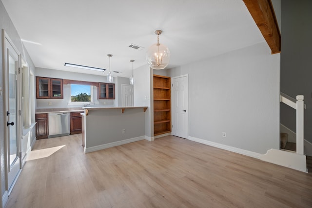 kitchen featuring stainless steel dishwasher, light wood-type flooring, pendant lighting, and kitchen peninsula