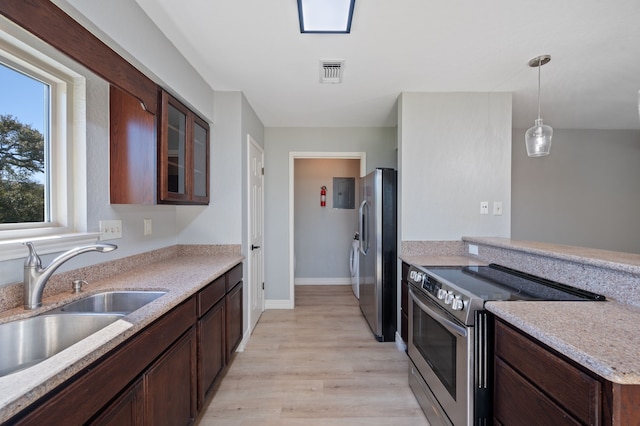 kitchen featuring sink, decorative light fixtures, light hardwood / wood-style floors, dark brown cabinetry, and appliances with stainless steel finishes