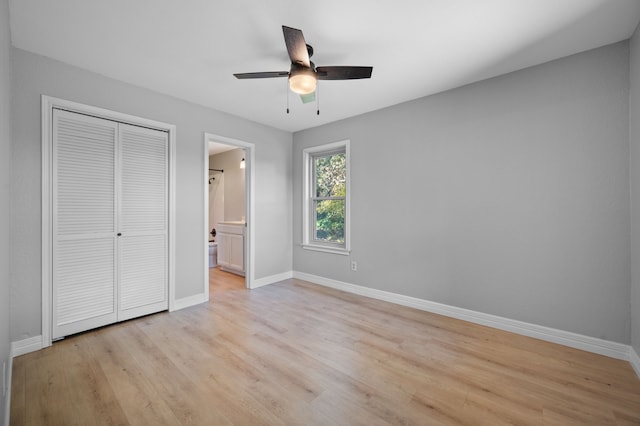 unfurnished bedroom with connected bathroom, a closet, ceiling fan, and light wood-type flooring