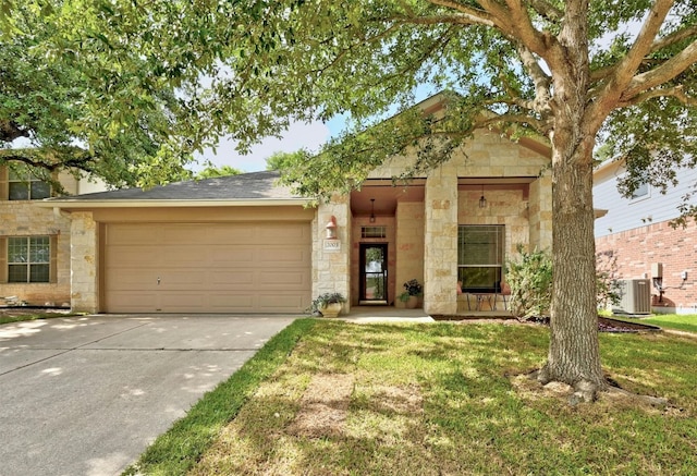 view of front facade featuring central AC unit, a front yard, and a garage