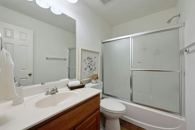 full bathroom featuring tile patterned floors, vanity, combined bath / shower with glass door, and toilet