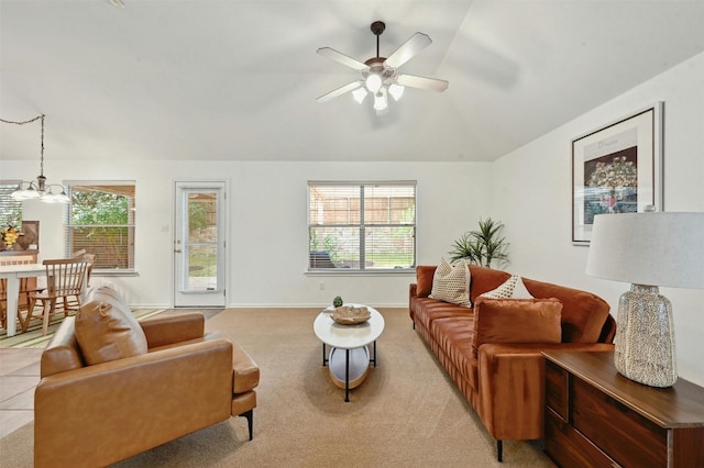 living room featuring ceiling fan with notable chandelier, light colored carpet, and vaulted ceiling