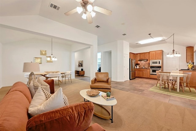 tiled living room with vaulted ceiling and ceiling fan with notable chandelier