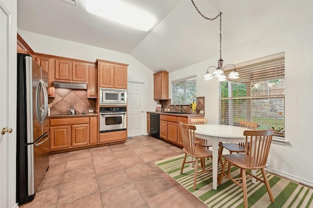 kitchen featuring lofted ceiling, black appliances, sink, backsplash, and pendant lighting