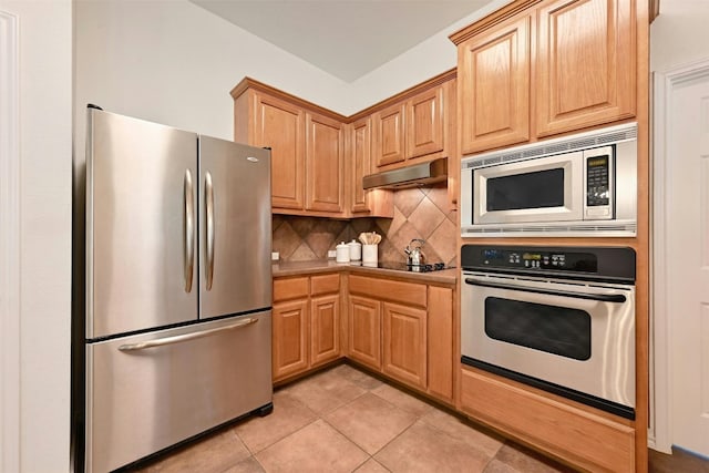 kitchen featuring stainless steel appliances, light tile patterned floors, and decorative backsplash