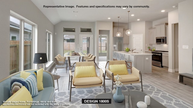 living room featuring sink and vaulted ceiling