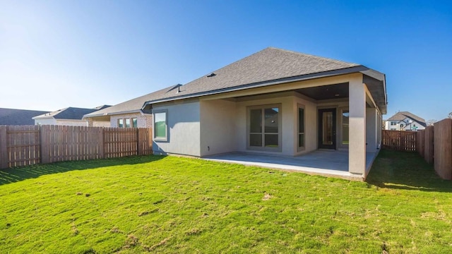 rear view of house featuring a lawn and a patio