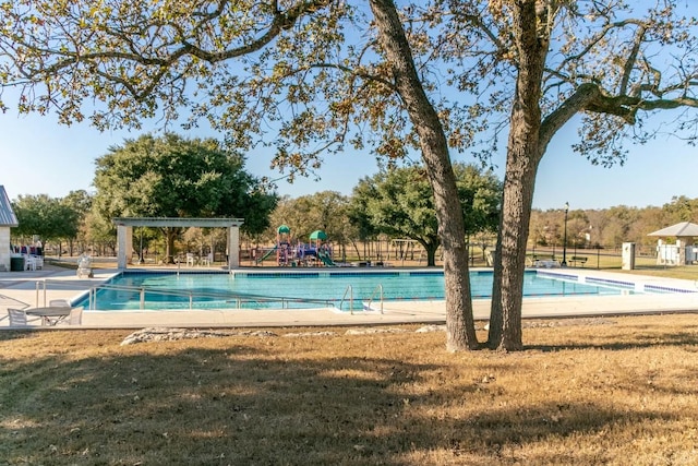 view of swimming pool featuring a playground and a lawn