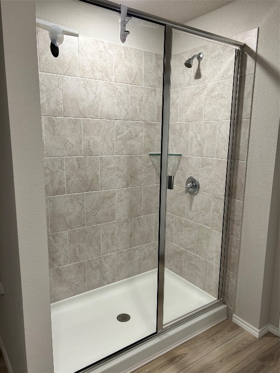 bathroom featuring walk in shower and hardwood / wood-style floors