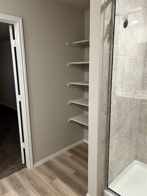 bathroom featuring hardwood / wood-style flooring and tiled shower