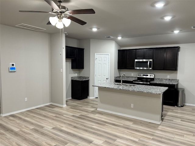 kitchen with sink, appliances with stainless steel finishes, ceiling fan, a kitchen island with sink, and light hardwood / wood-style flooring