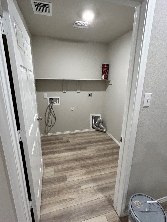 washroom featuring light hardwood / wood-style floors, electric dryer hookup, hookup for a gas dryer, and washer hookup