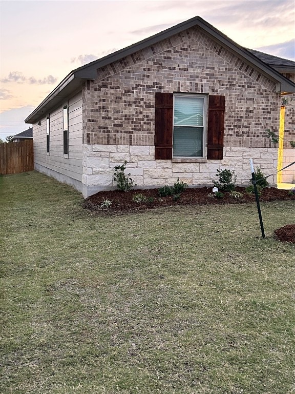 property exterior at dusk with a lawn