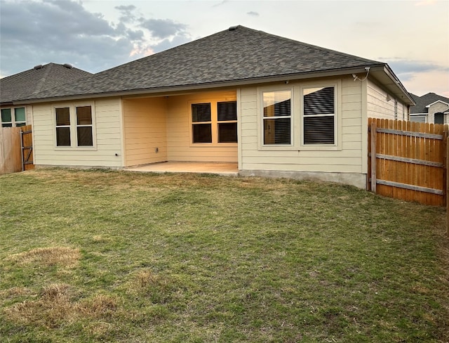 rear view of house with a patio and a yard