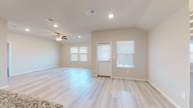 empty room with ceiling fan, light wood-type flooring, and vaulted ceiling