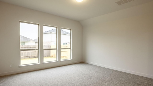 unfurnished room featuring lofted ceiling and carpet floors