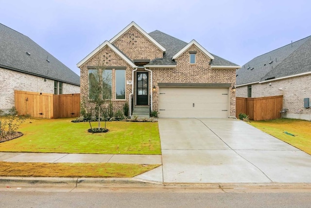 176 Plumbago Loop, Bastrop, TX 78602 - view of front facade featuring brick siding, an attached garage, driveway, and a shingled roof