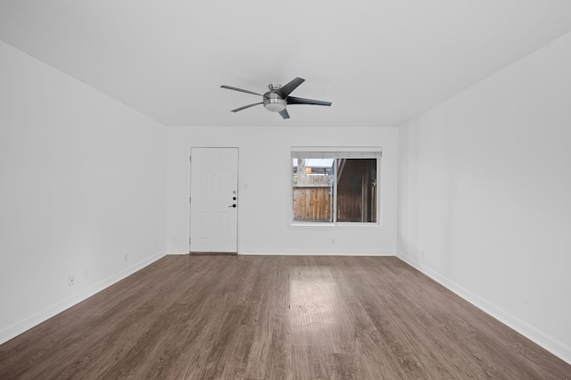 spare room featuring dark wood-type flooring and ceiling fan