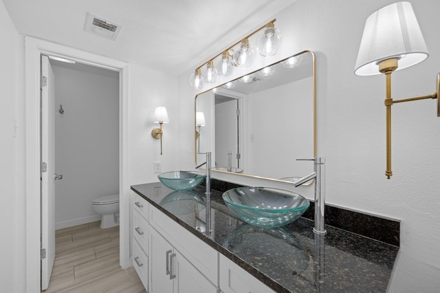 bathroom with wood-type flooring, vanity, and toilet