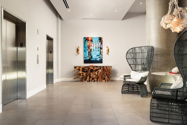 sitting room with elevator and light tile patterned floors