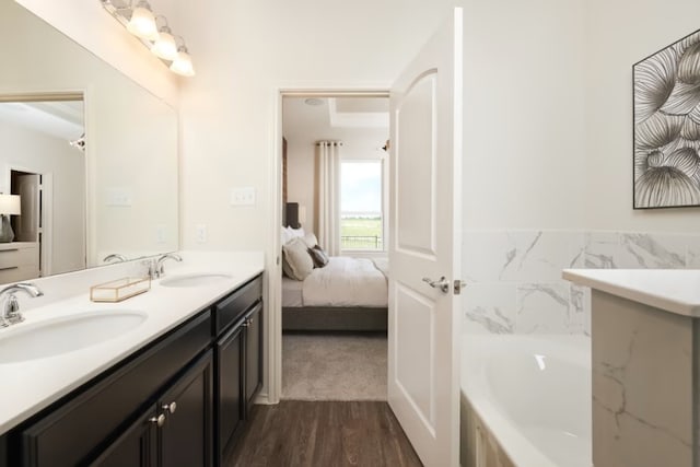 bathroom with a bathing tub, hardwood / wood-style floors, and vanity