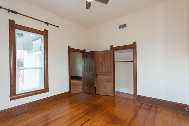 unfurnished bedroom featuring a ceiling fan, baseboards, visible vents, and light wood finished floors