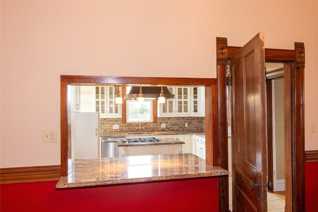 kitchen featuring tasteful backsplash, white cabinets, glass insert cabinets, light stone countertops, and stainless steel dishwasher