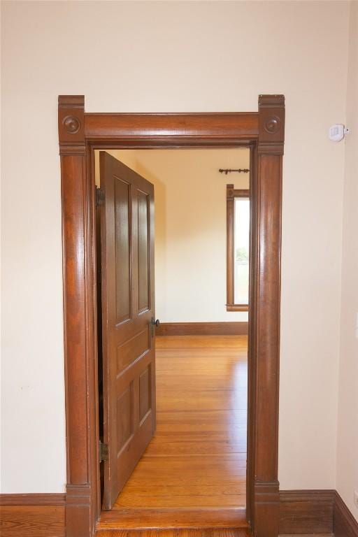 hall featuring wood finished floors and baseboards