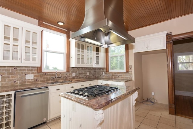 kitchen with light tile patterned floors, stone countertops, island range hood, decorative backsplash, and appliances with stainless steel finishes