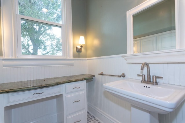 bathroom featuring a wainscoted wall and a sink