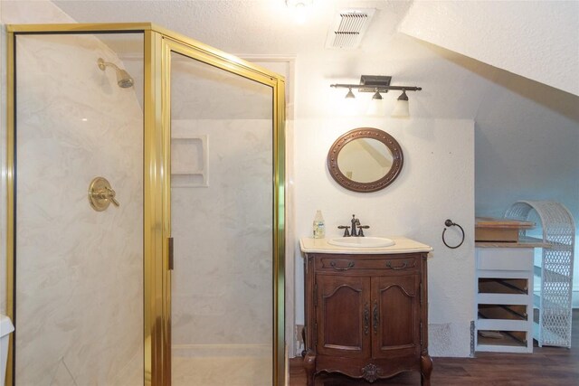 bathroom with a stall shower, visible vents, vanity, and wood finished floors