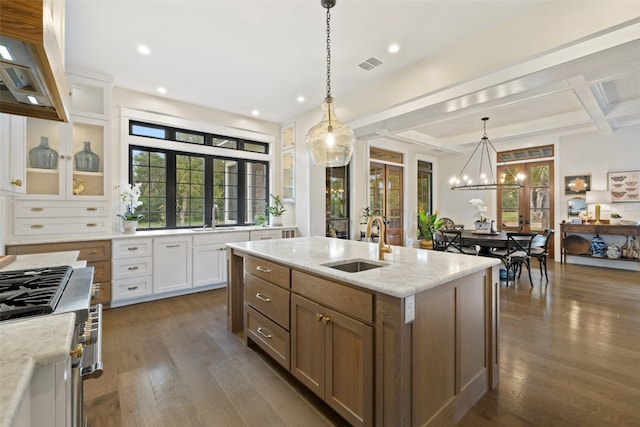 kitchen with a kitchen island with sink, dark hardwood / wood-style flooring, white cabinets, and pendant lighting