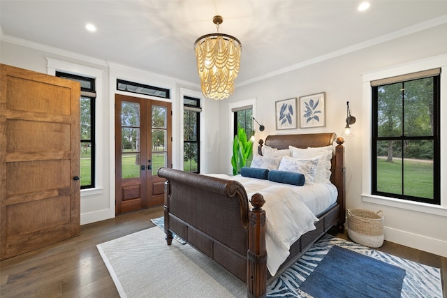 bedroom featuring dark wood-type flooring, access to outside, french doors, ornamental molding, and a notable chandelier