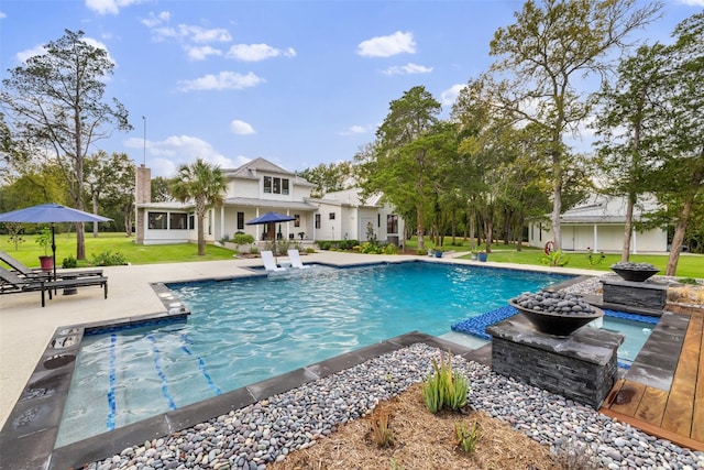 view of swimming pool featuring a patio area and a yard