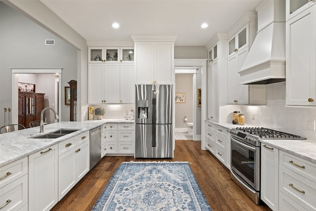 kitchen featuring premium range hood, light stone countertops, dark hardwood / wood-style floors, and appliances with stainless steel finishes