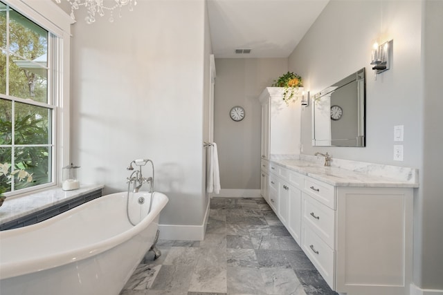 bathroom featuring vanity, an inviting chandelier, and a bathtub