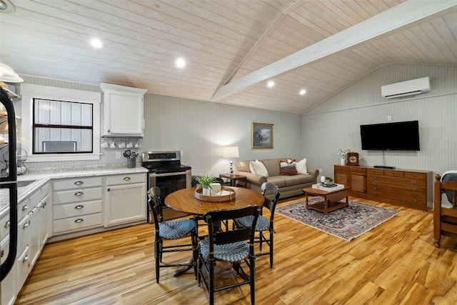 kitchen featuring light wood-type flooring, white cabinetry, and an AC wall unit