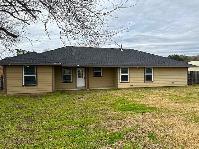 back of property featuring a yard