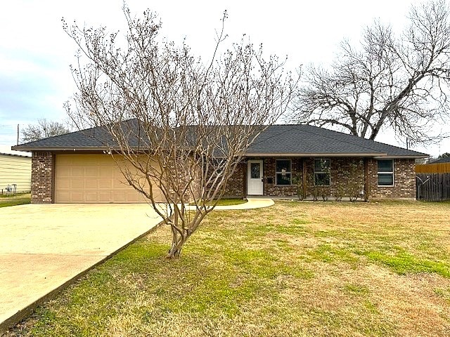 ranch-style house featuring a front lawn and a garage