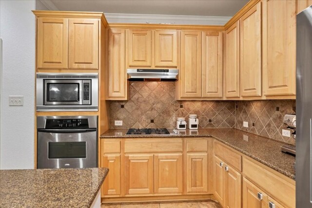 kitchen with dark stone countertops, decorative backsplash, ornamental molding, and appliances with stainless steel finishes