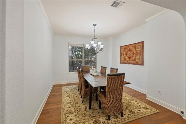 dining area with ornamental molding, dark hardwood / wood-style floors, and a chandelier