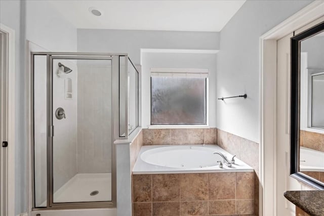 bathroom featuring a stall shower, vanity, and a bath