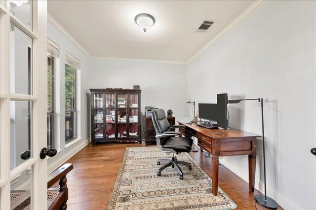 home office featuring ornamental molding, visible vents, baseboards, and wood finished floors