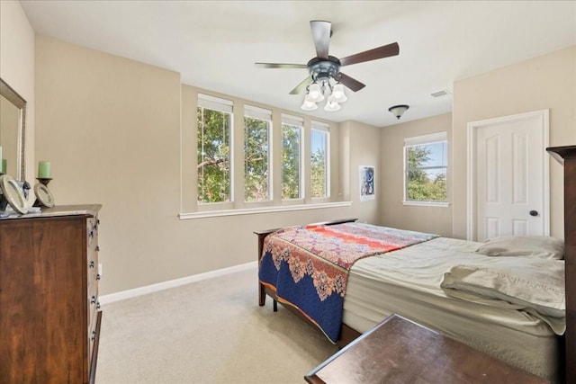 bedroom featuring a ceiling fan, light colored carpet, visible vents, and baseboards